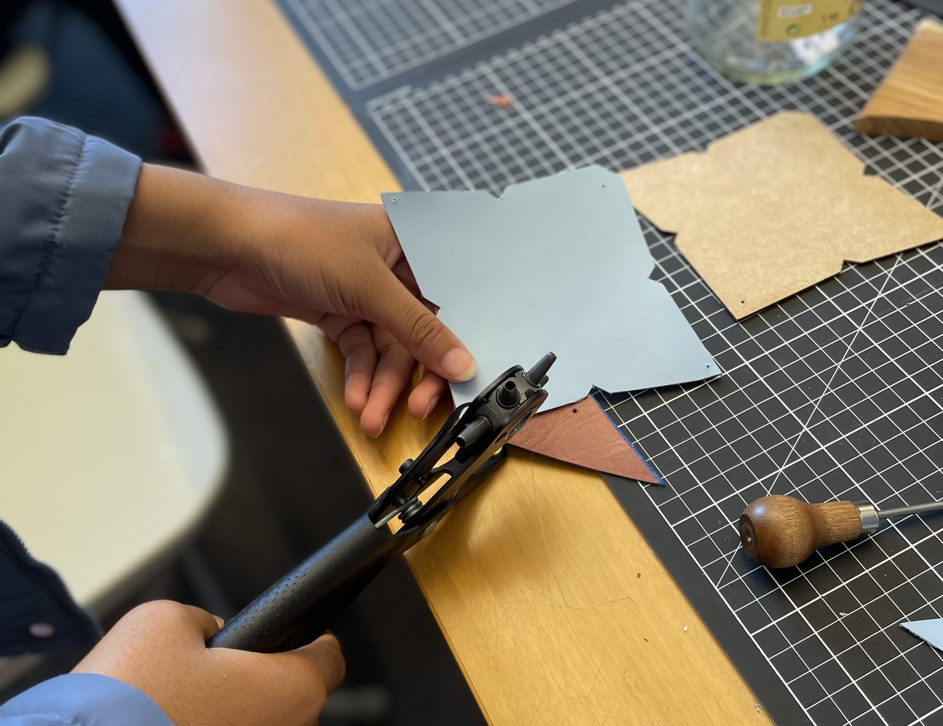 Student cutting leather