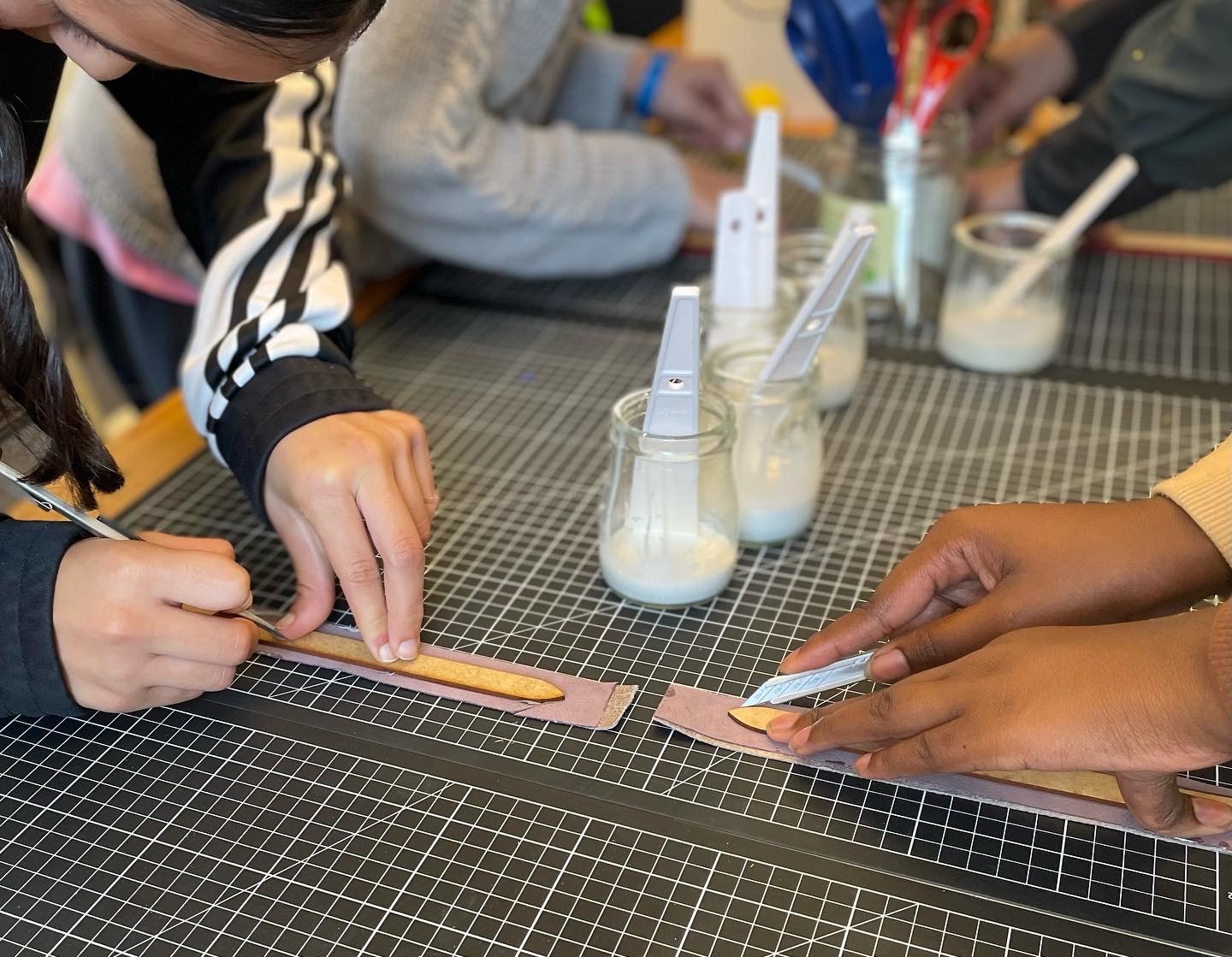 Student cutting leather