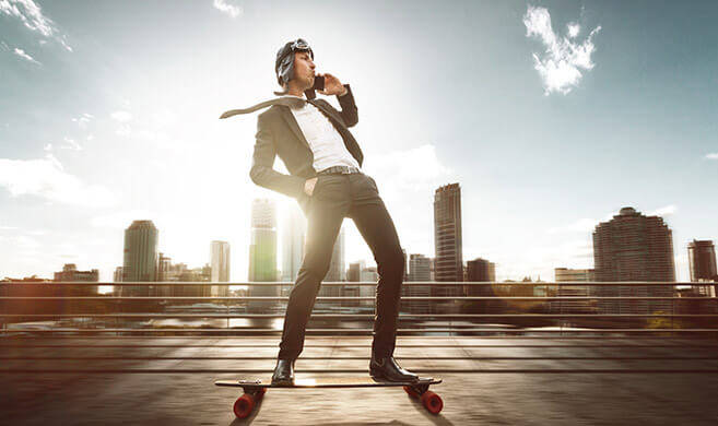 overconfident young business man with a phone on a skateboard