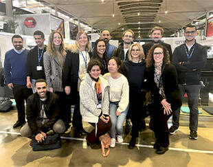 A group of people, likely employees or colleagues, posing together for a group photo. 