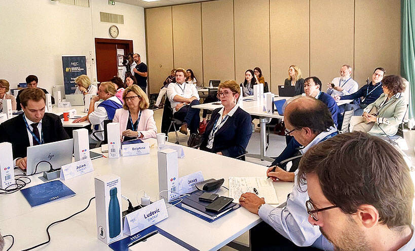 People sitting around a long table, discussing the topic of whether AI will replace humans or give them superpowers.